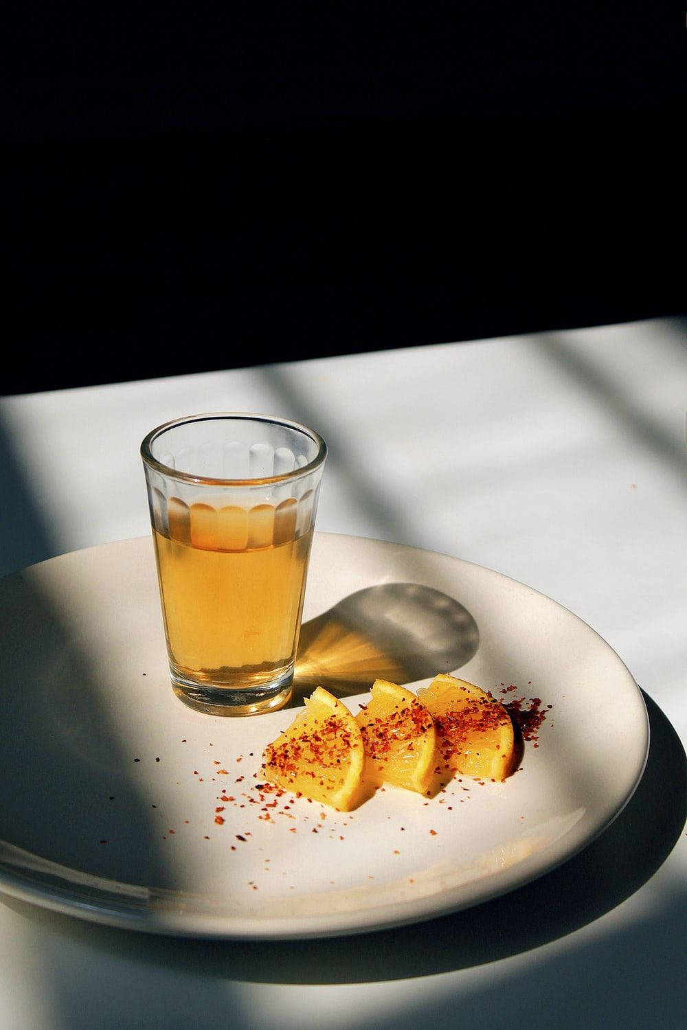 Tequila With Lemon Slices On Plate Background