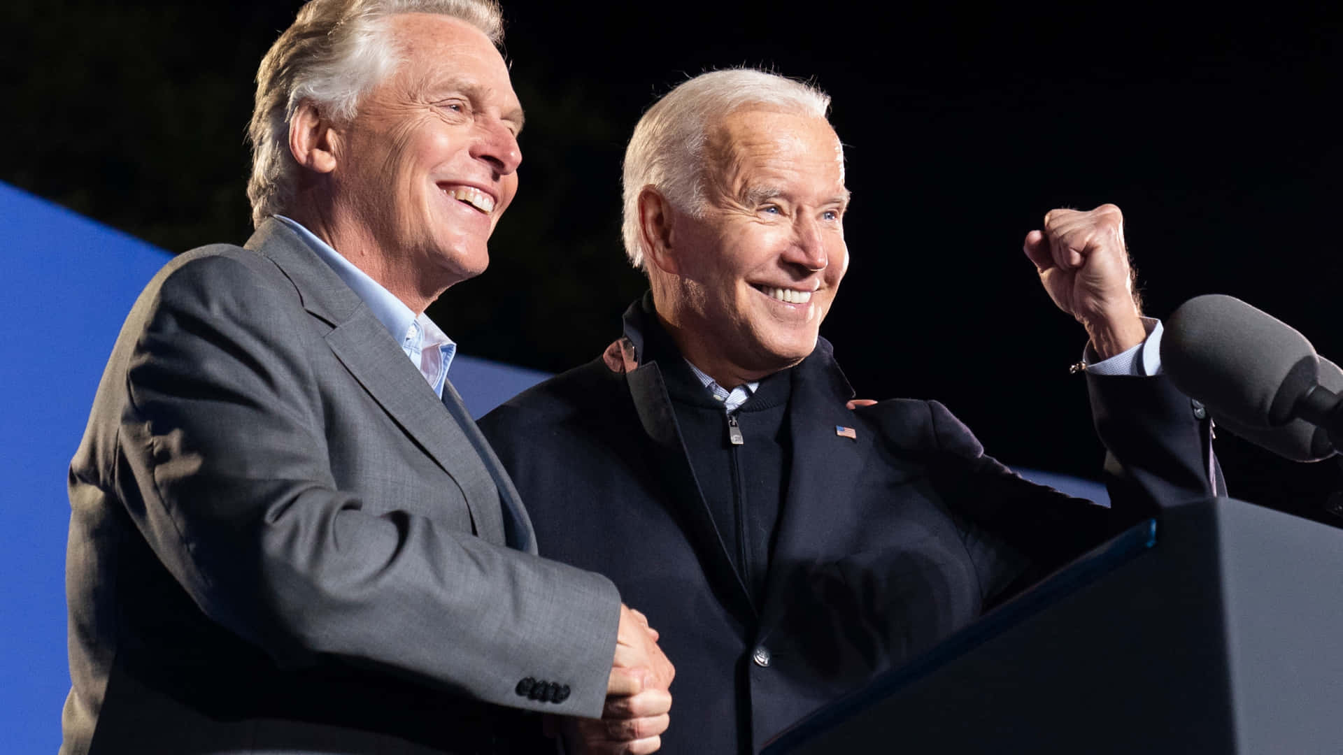 Terry Mcauliffe On A Podium With Joe Biden Background
