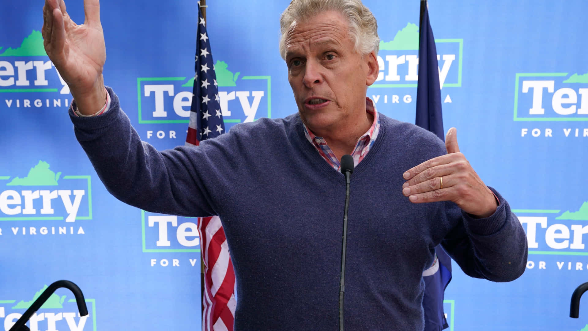 Terry Mcauliffe Speaking At A Political Rally Background