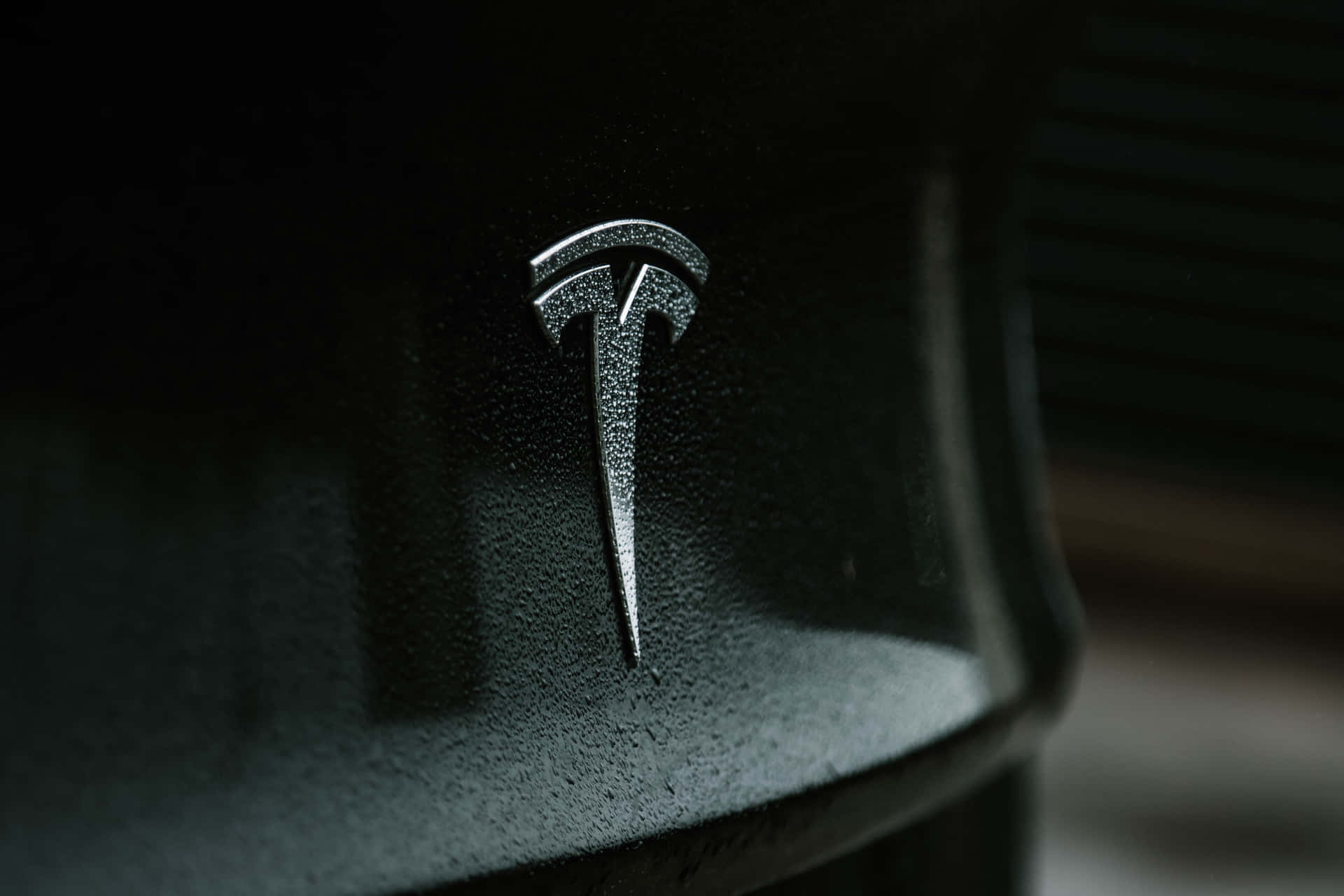 Tesla Logo On The Side Of A Black Car Background