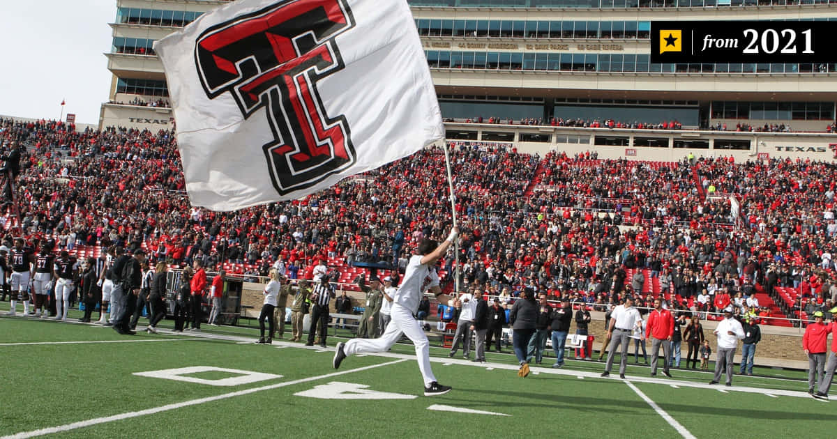 Texas Tech Football Player Runs With A Flag Background