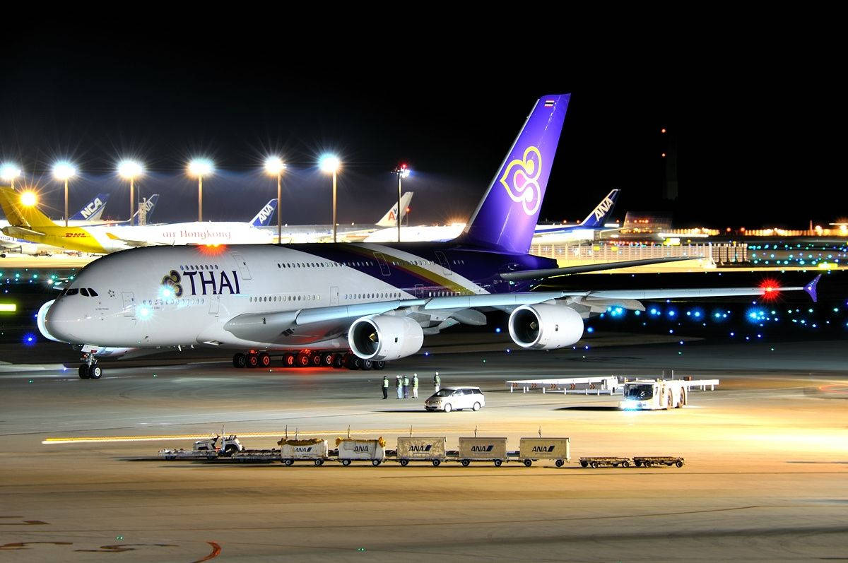 Thai Airways Airplane With Cargo Cars Background