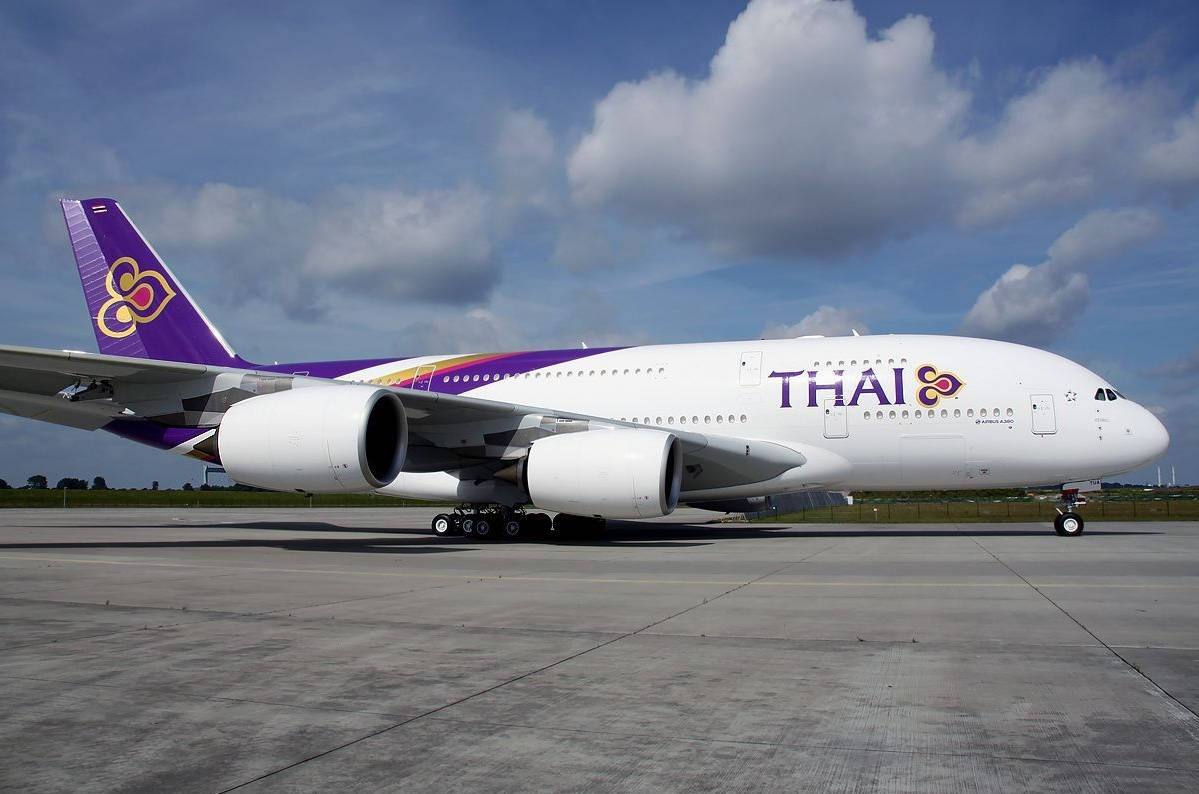 Thai Airways Airplane With Cloudy Sky Background