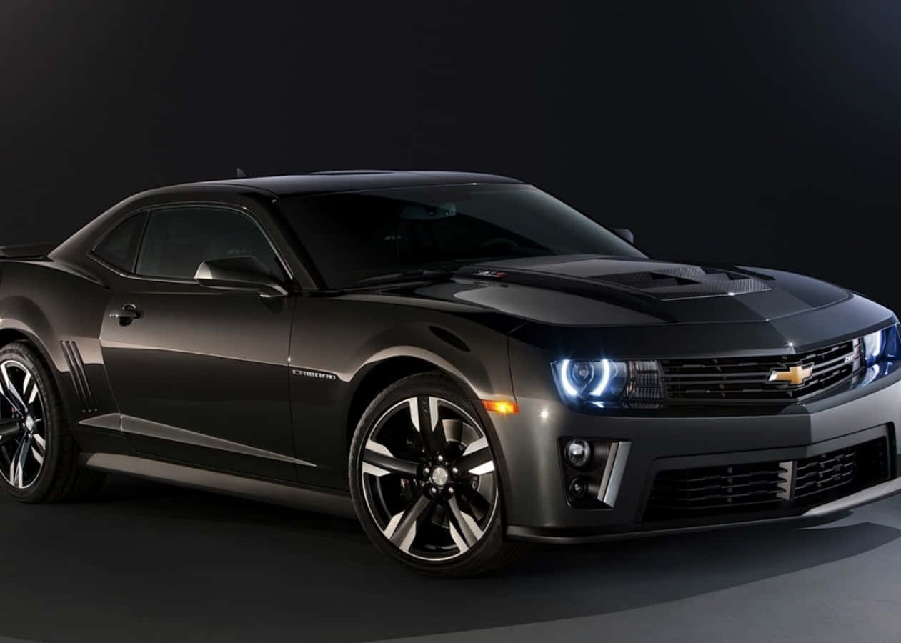 The 2013 Chevrolet Camaro Is Shown In A Dark Background Background