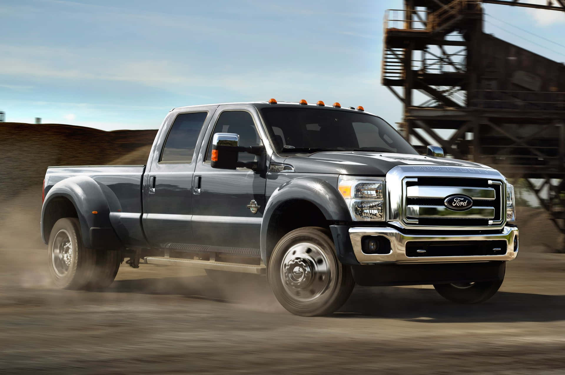 The 2014 Ford F-350 F-450 Is Driving On A Dirt Road Background