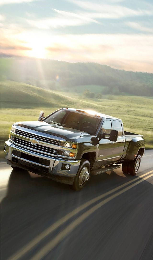 The 2016 Chevrolet Silverado Is Driving Down A Country Road