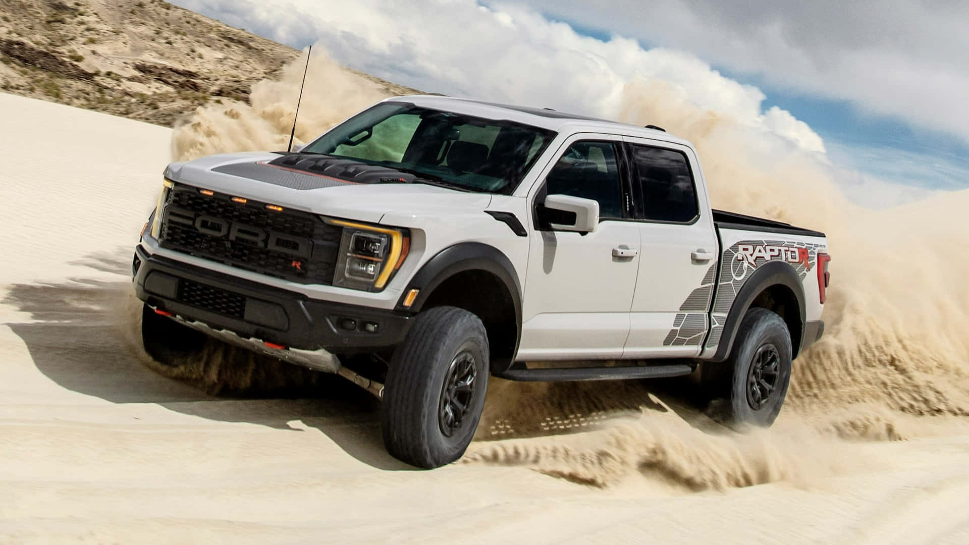 The 2019 Ford F-150 Raptor Is Driving Through The Desert Background