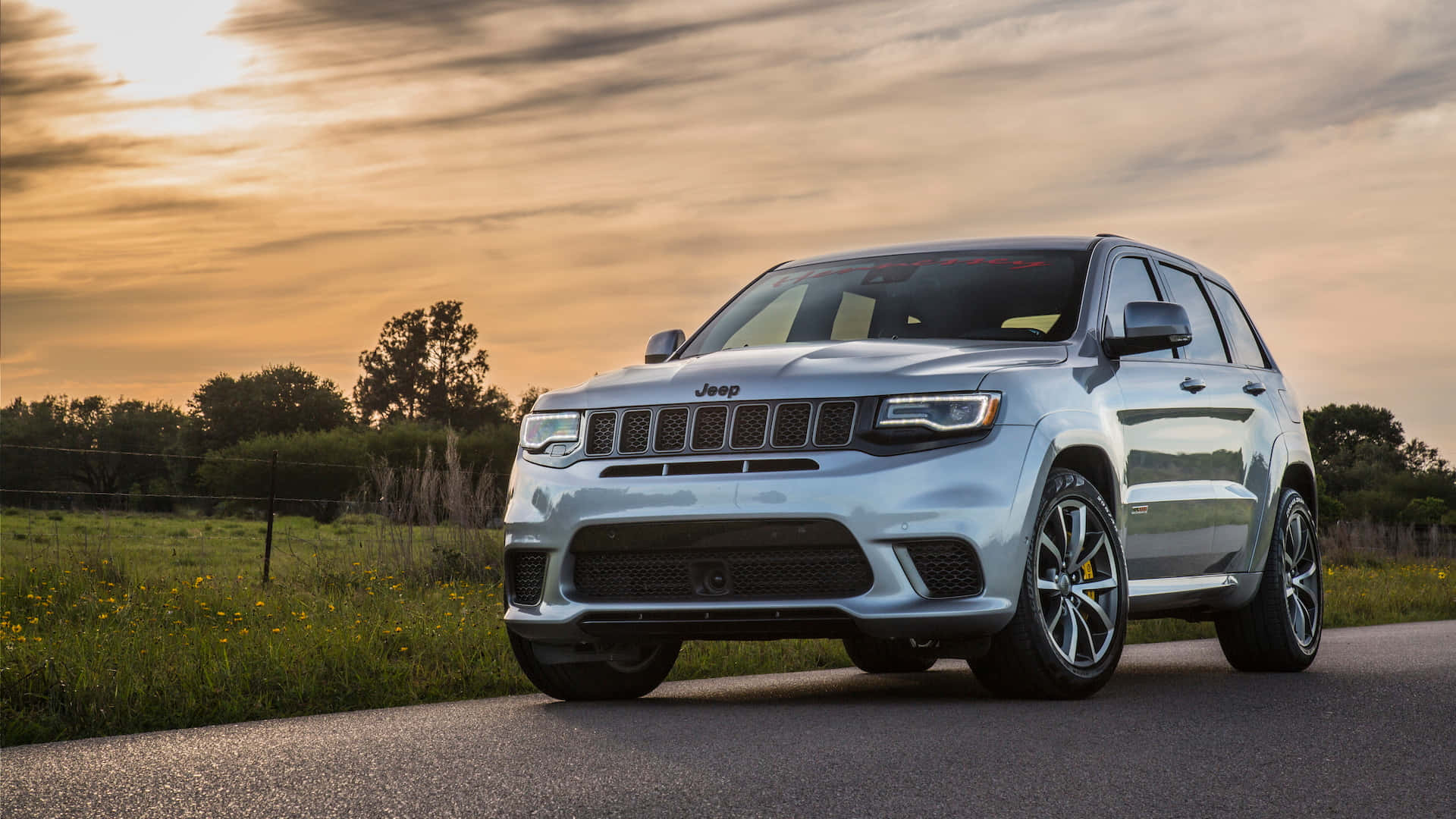 The 2019 Jeep Grand Cherokee Is Driving Down A Country Road