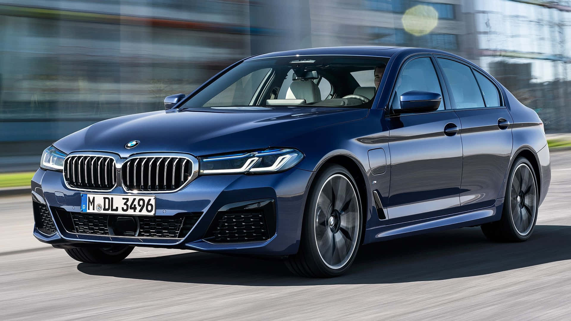The 2020 Bmw 5 Series Sedan Is Driving Down The Street Background