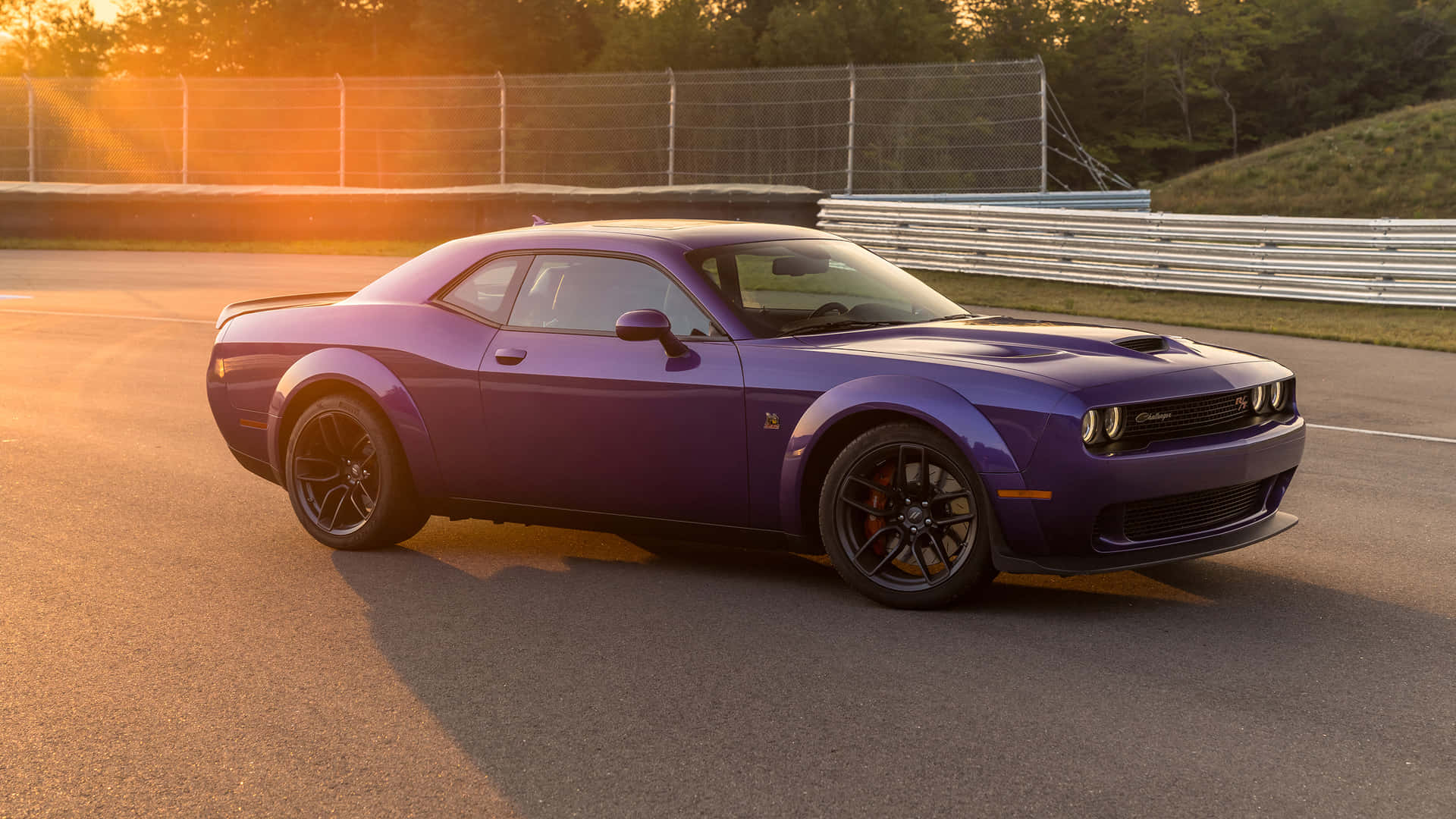 The 2020 Dodge Challenger Is Driving Down A Track Background