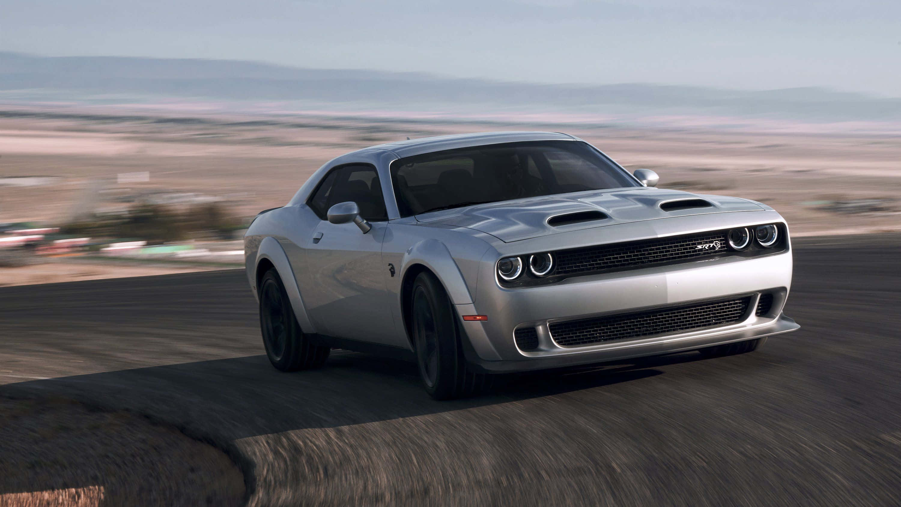 The 2020 Dodge Challenger Is Driving On A Road Background