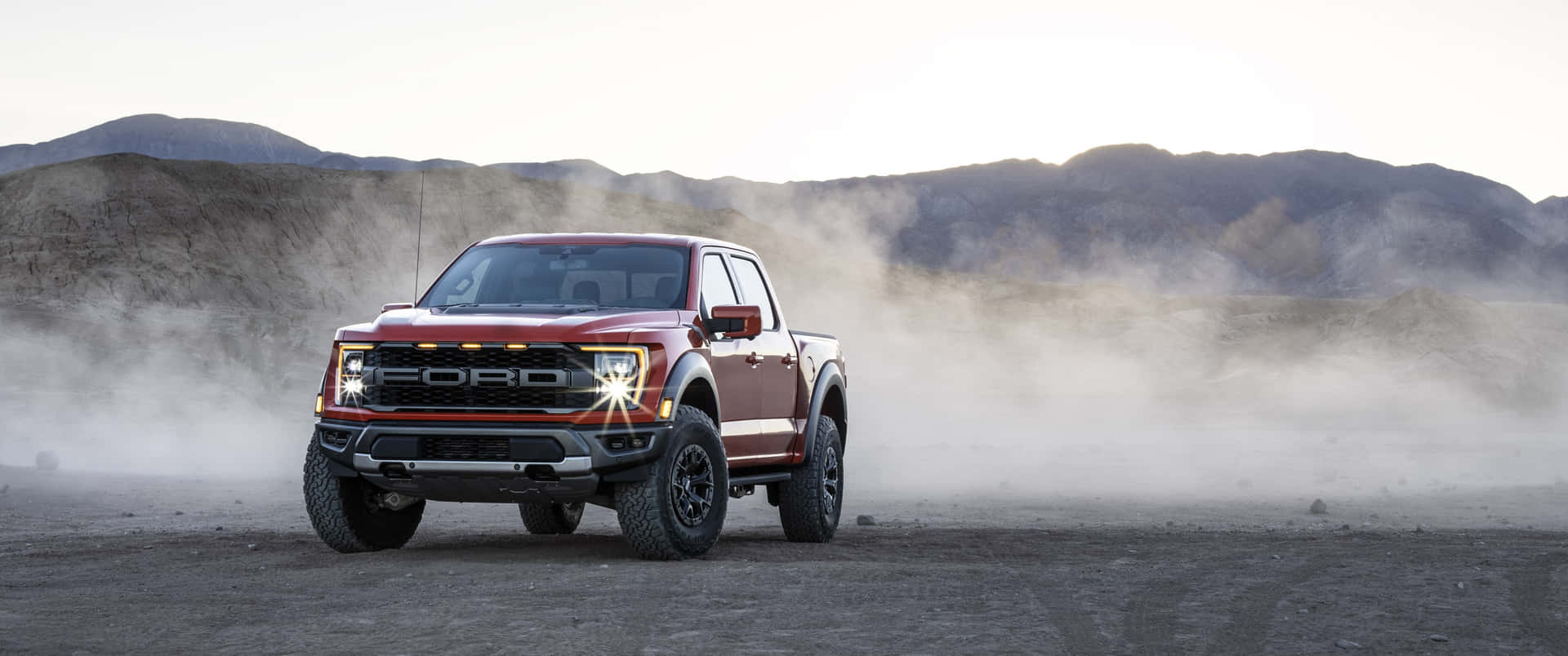 The 2020 Ford F-150 Raptor Is Driving Through The Desert Background