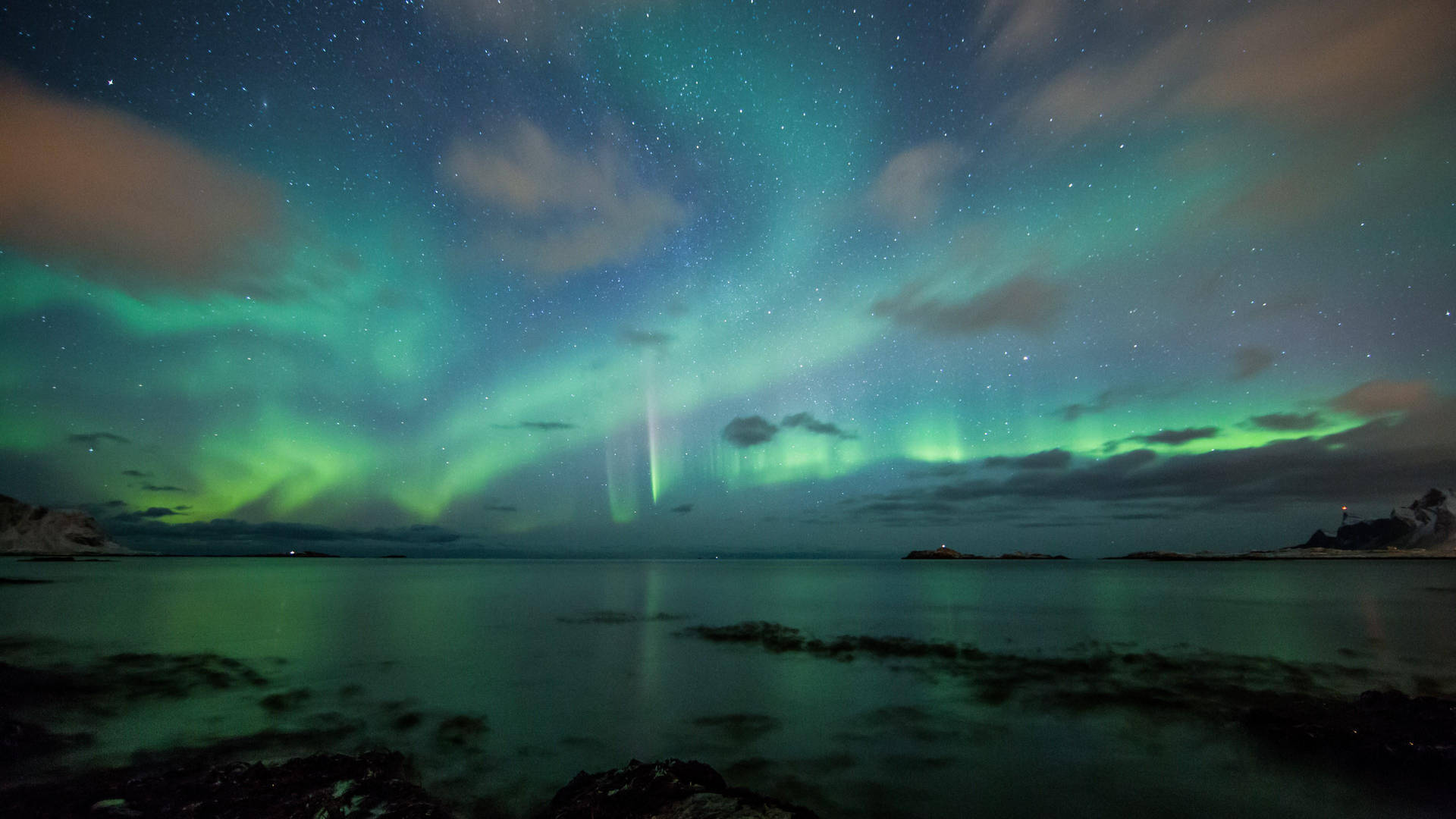 The Aurora Borealis Over A Body Of Water Background