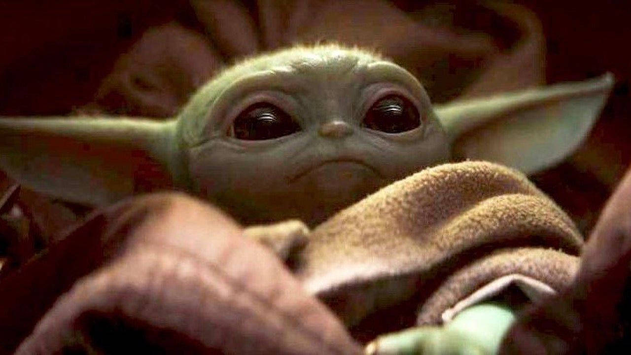 The Baby Yoda Is Sitting On A Blanket