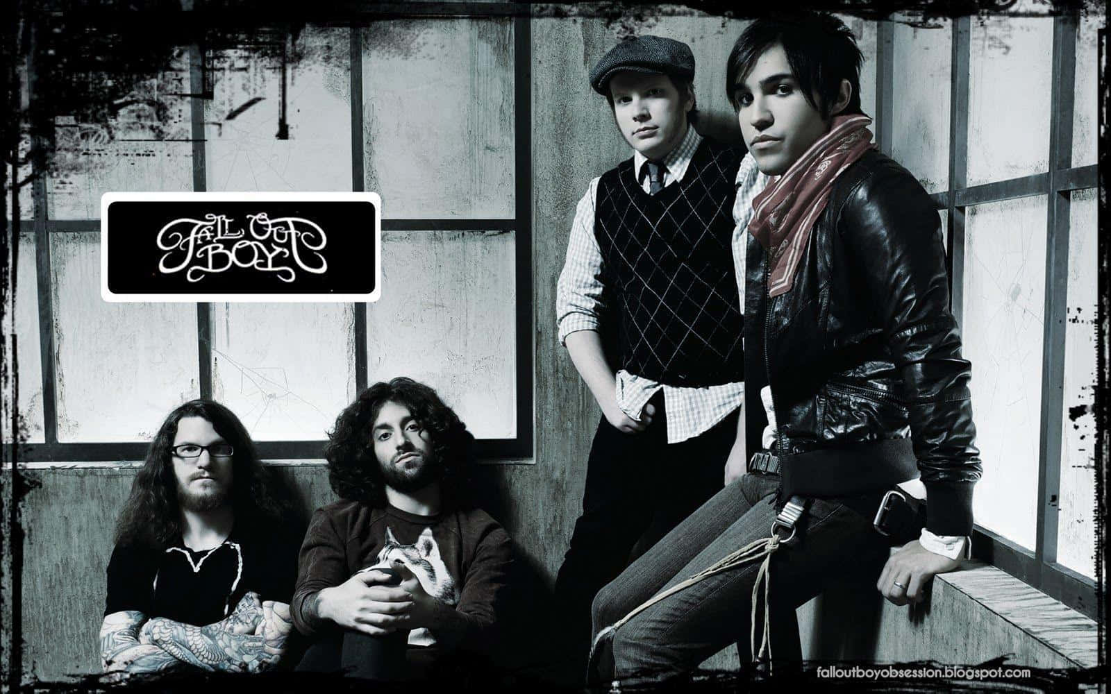 The Band Is Sitting On A Wall With A Sign