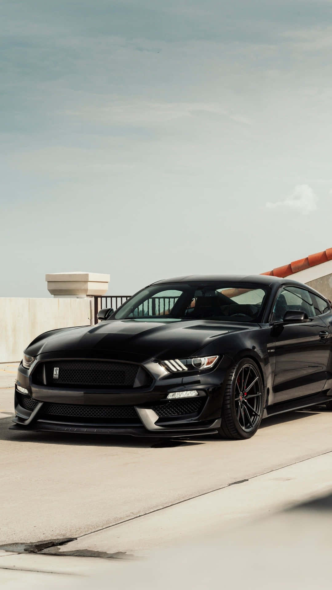 The Black Mustang Gt Is Parked On The Side Of The Road Background