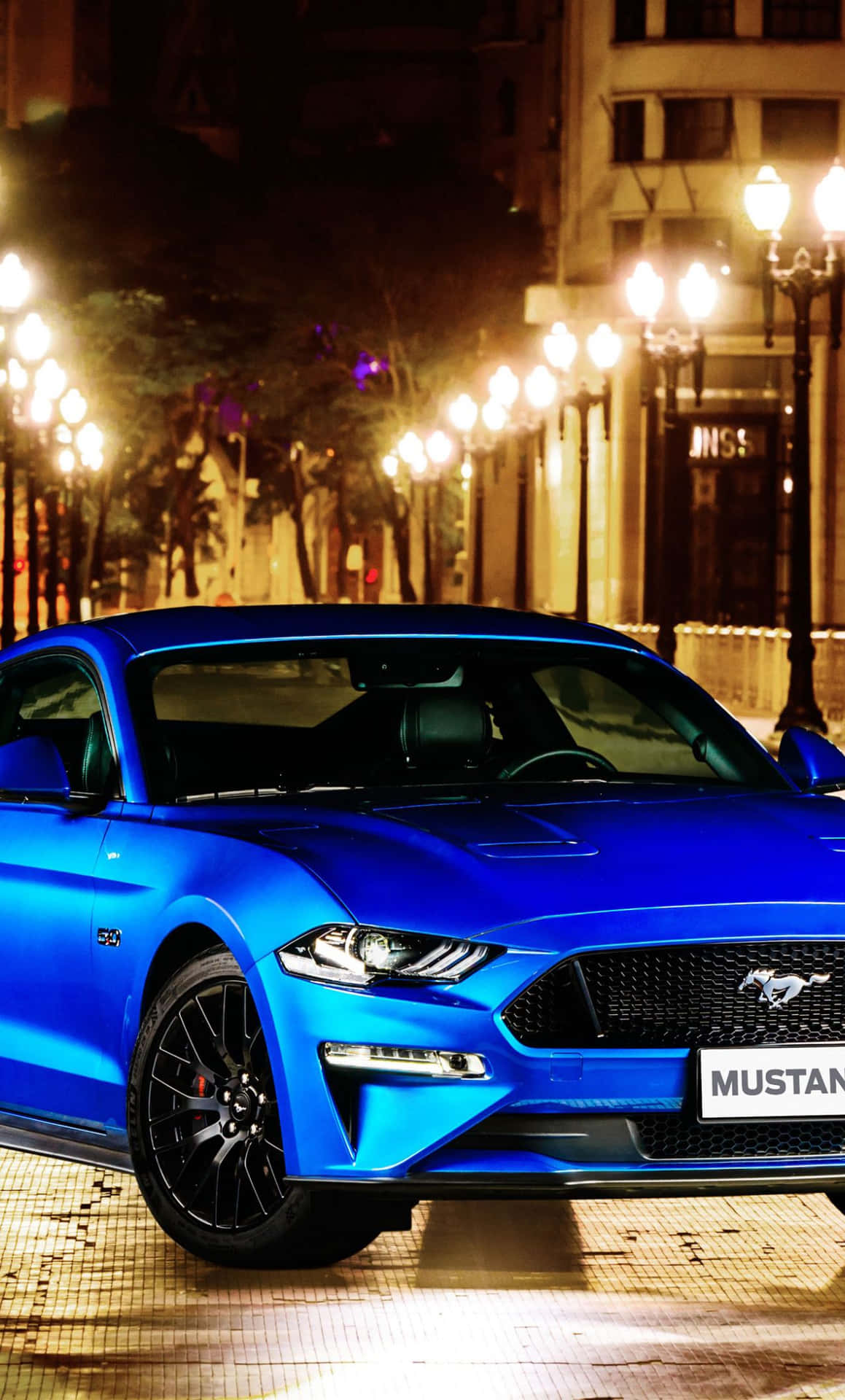 The Blue 2019 Ford Mustang Gt Is Parked On A City Street Background