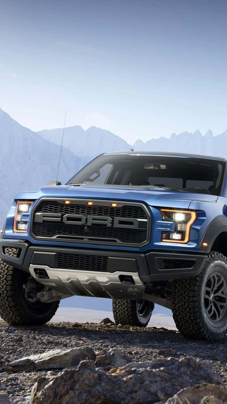 The Blue Ford F - 150 Raptor Is Parked On A Rocky Mountain