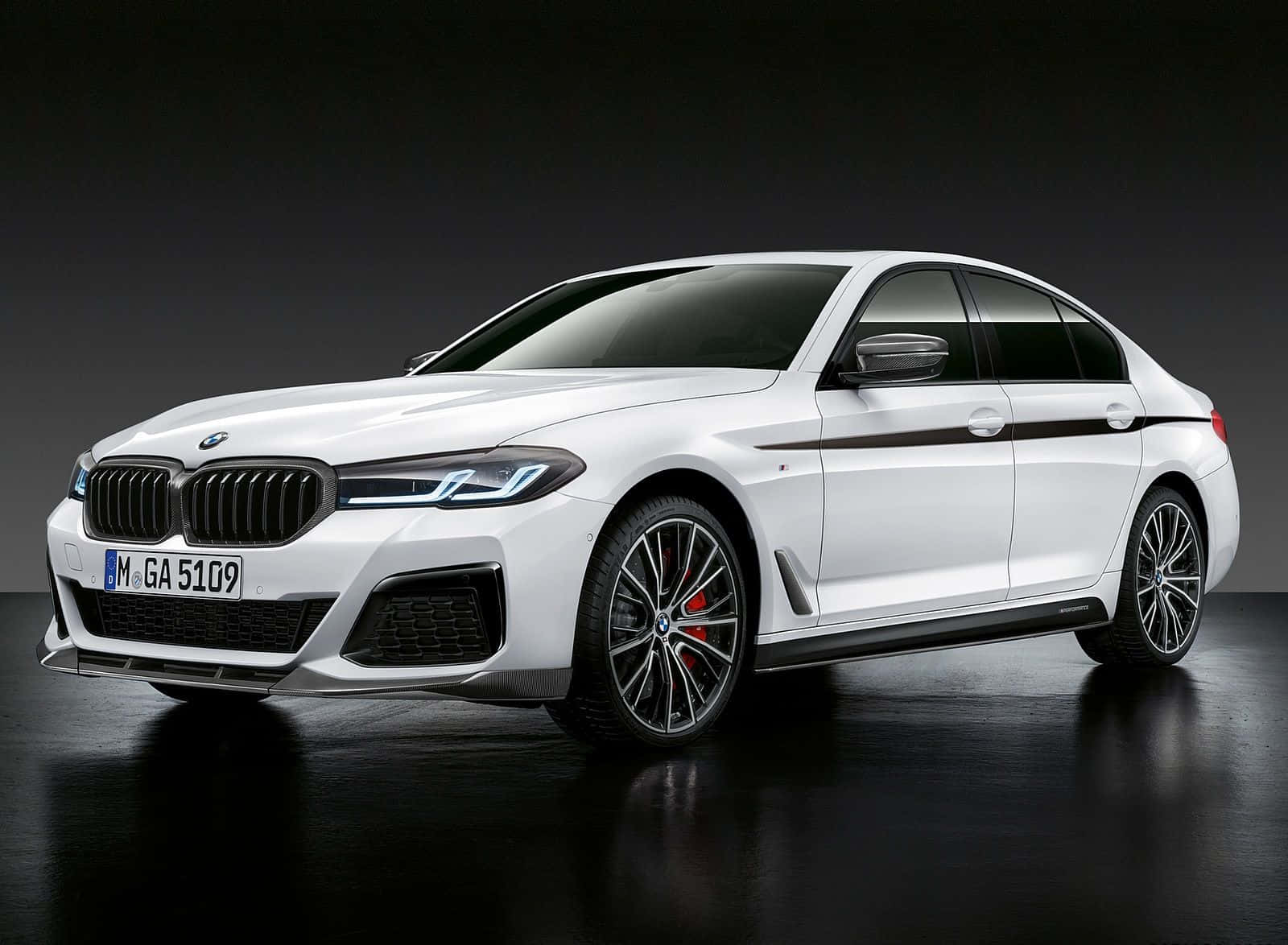 The Bmw M5 Gran Coupe Is Shown In A Dark Room