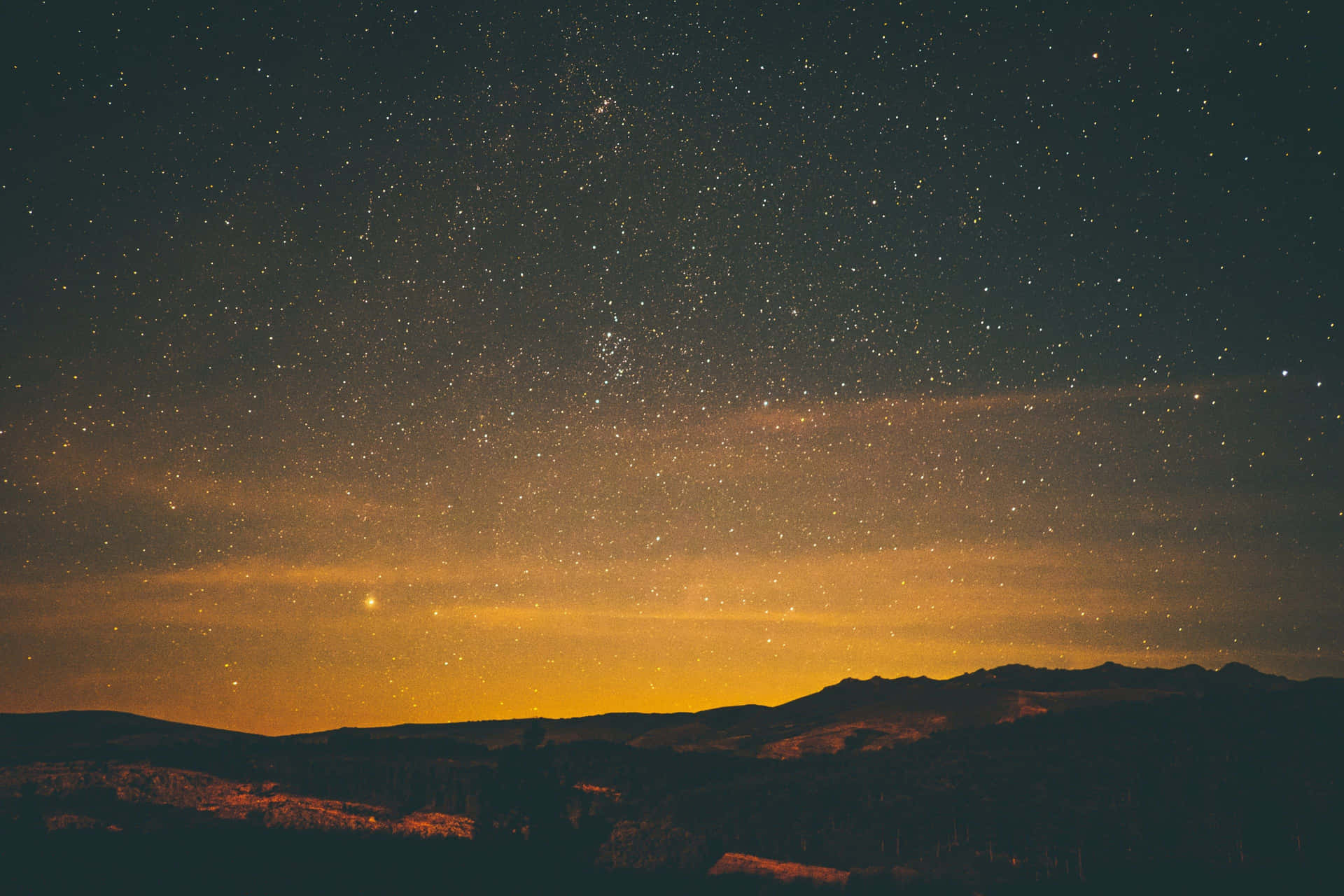 The Enchanting Night Sky Above The Hills Of A Village Background