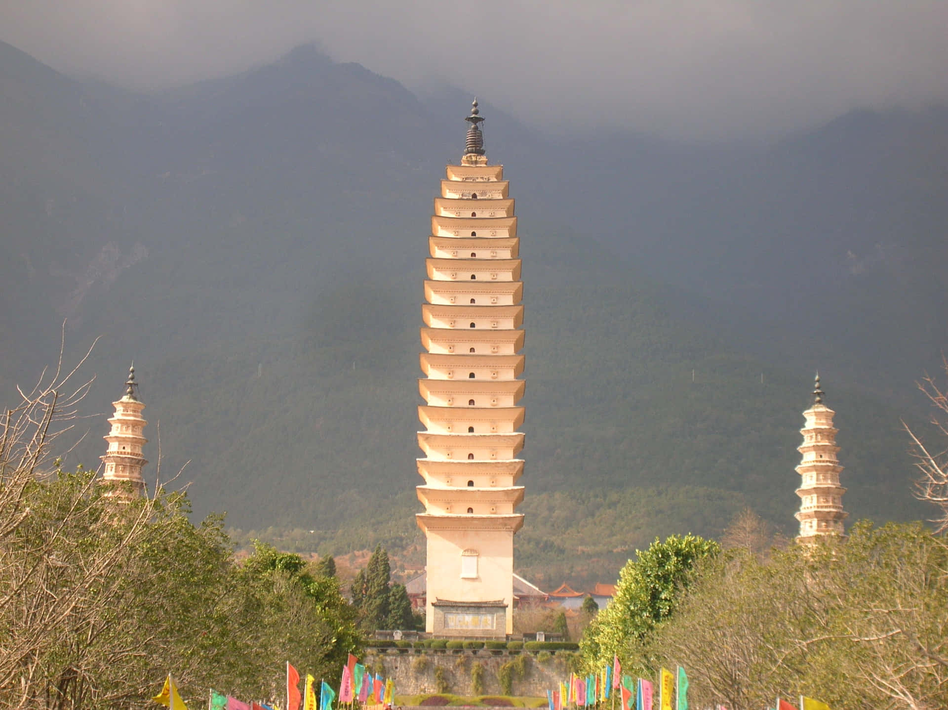 The Enchanting Three Pagodas Adorned With Colorful Prayer Flags Background