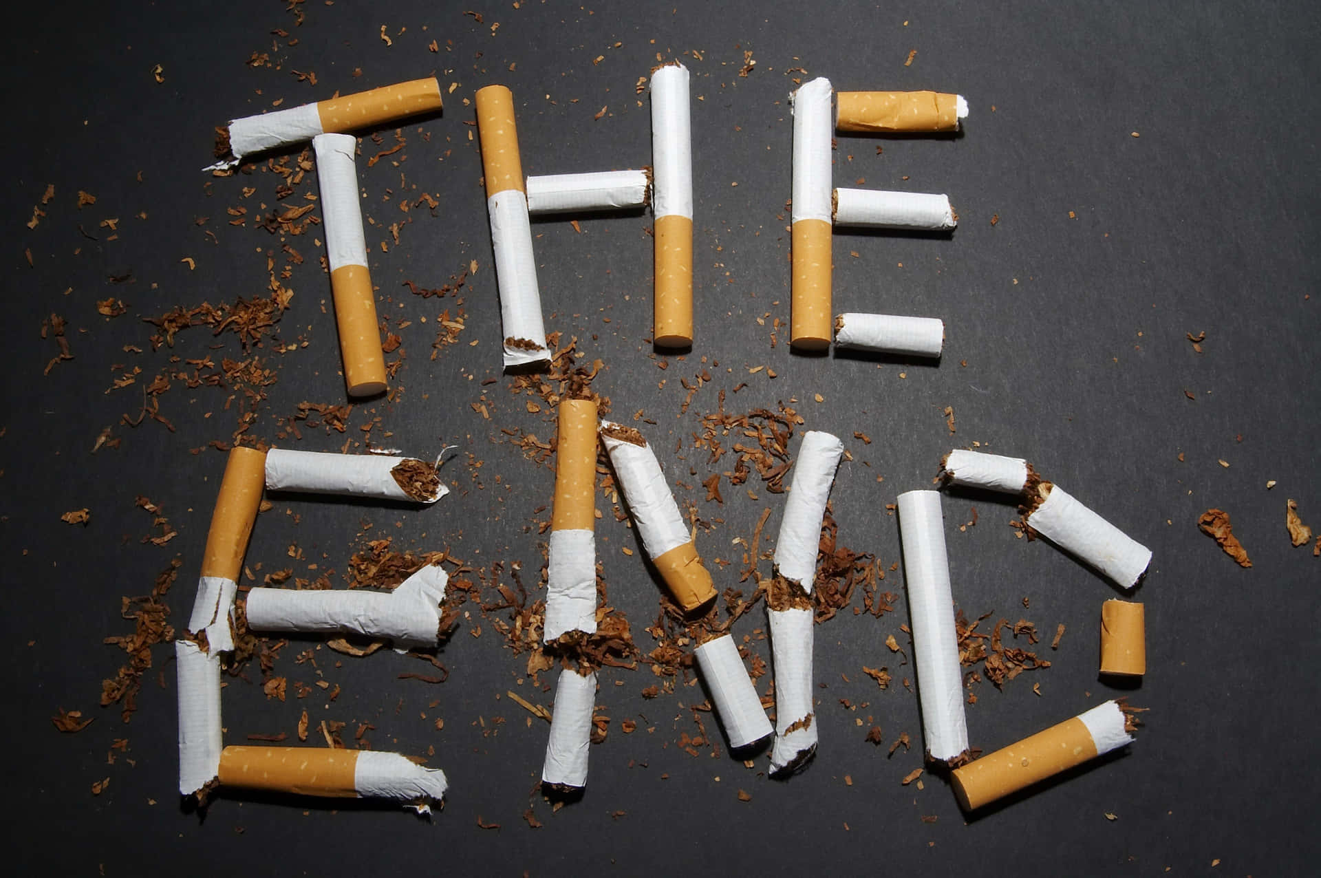 The End Of Cigarettes Spelled Out On A Black Background Background