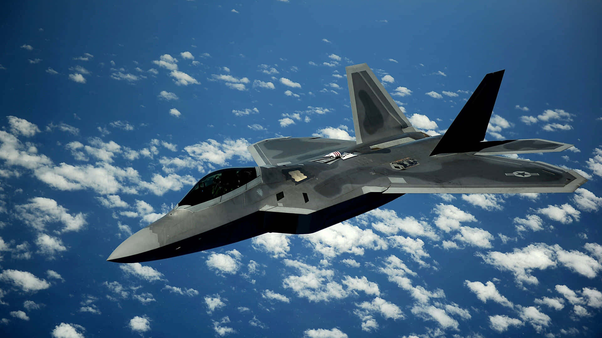 The F-22 Raptor Sleekly Flying Through The Sky Background