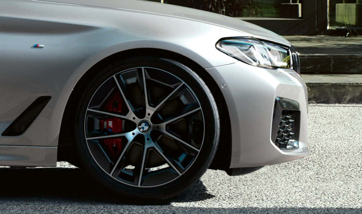 The Front Wheel Of A Silver Bmw M5 Background
