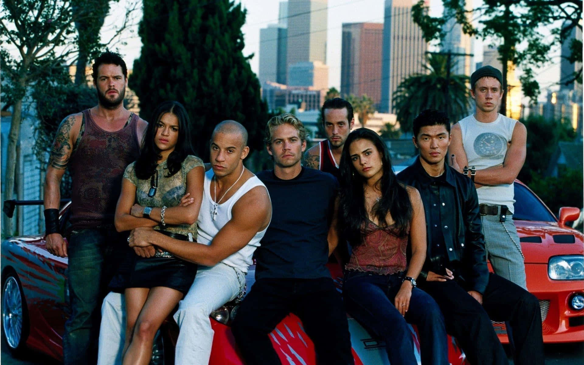 The Gang Of Street Racers From Fast And Furious 1 Hit The Road Background