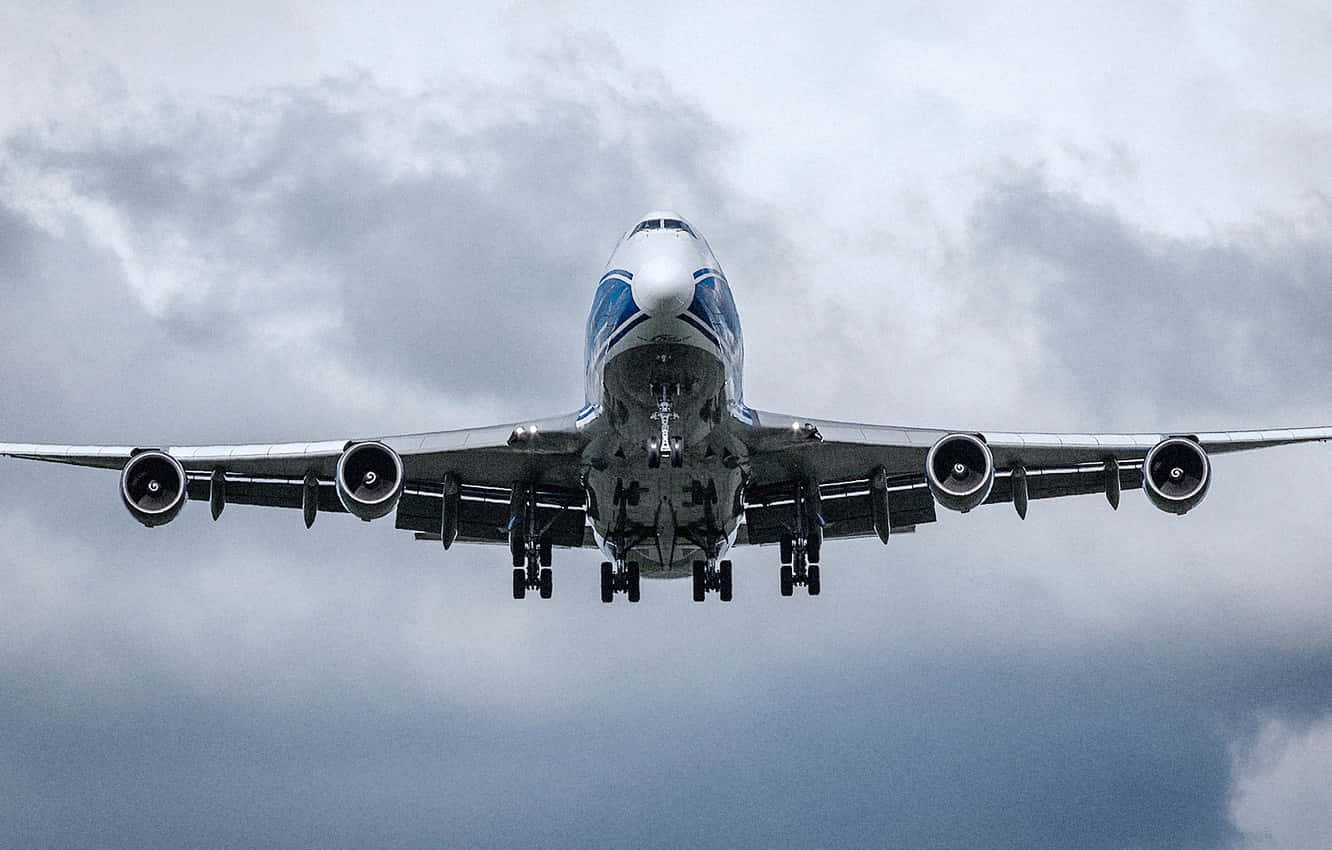 The Grandeur Of A Flying Jumbo Jet Background