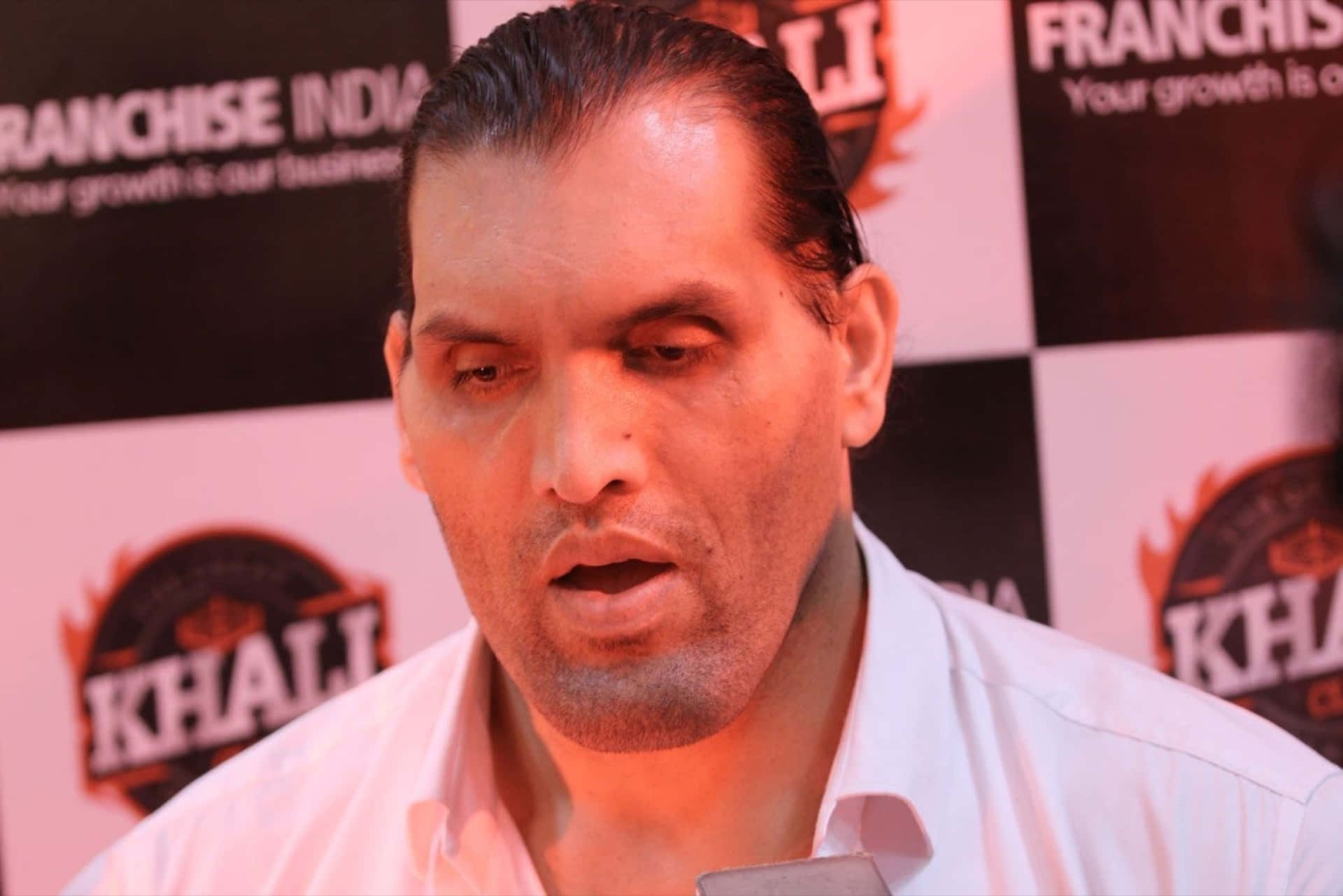 The Great Khali Displays An Intense Expression During A Wrestling Match. Background