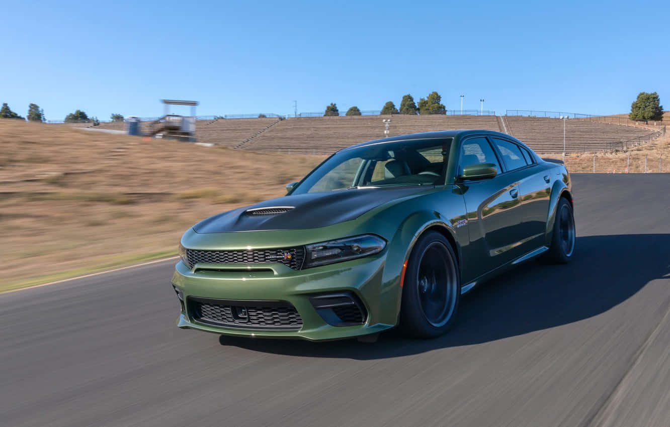 The Green 2019 Dodge Charger Srt Driving On A Race Track Background