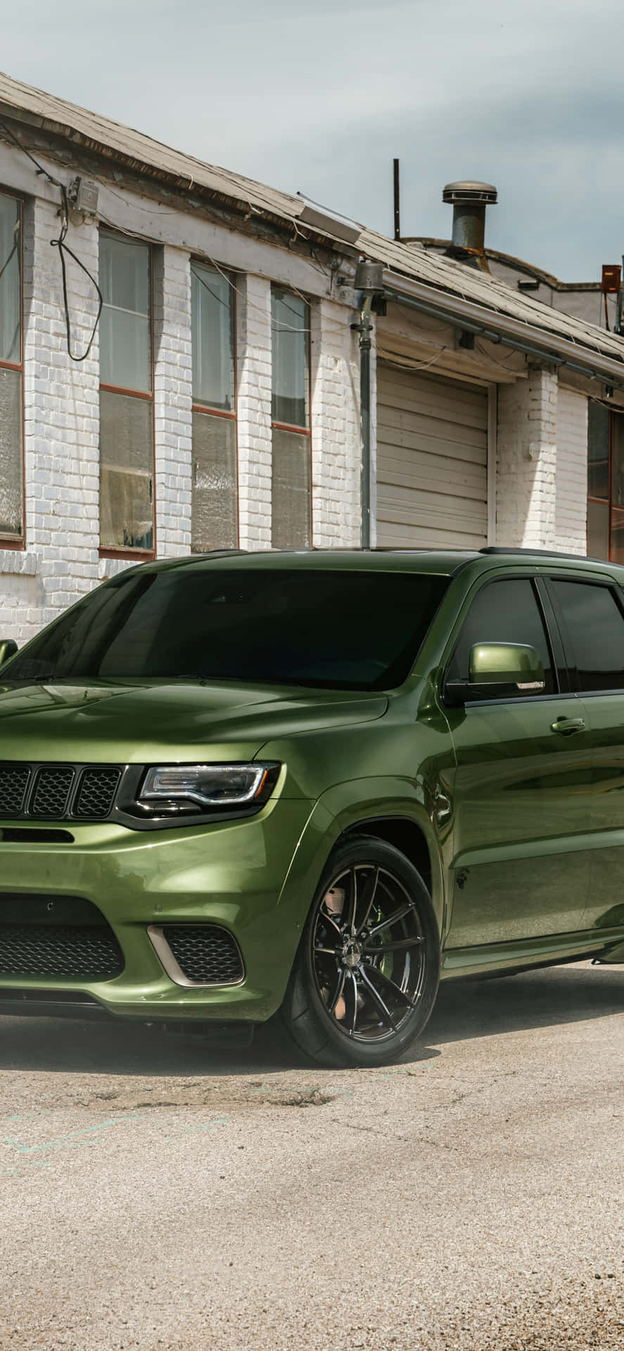 The Green 2019 Jeep Grand Cherokee Is Parked In Front Of A Building