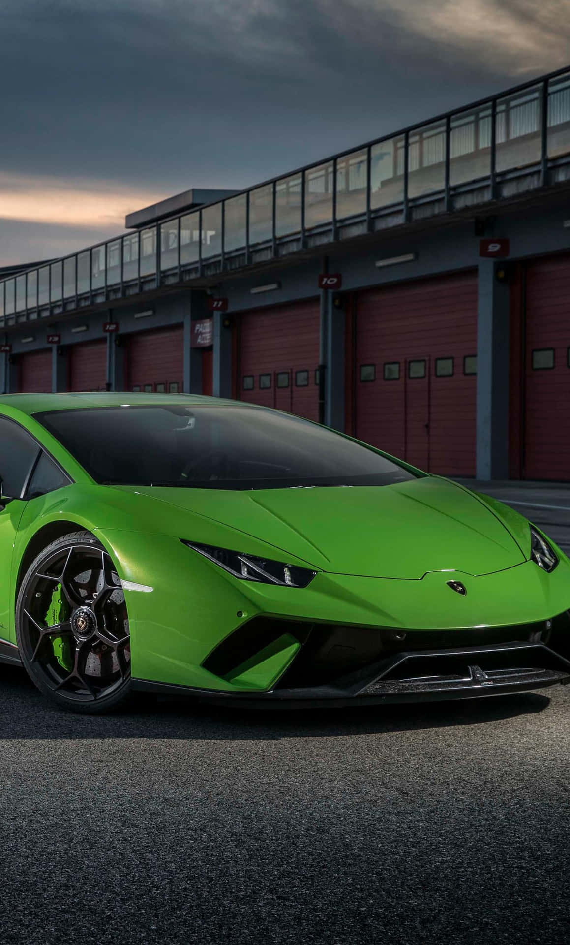 The Green Lamborghini Huracan Is Parked In Front Of A Building Background