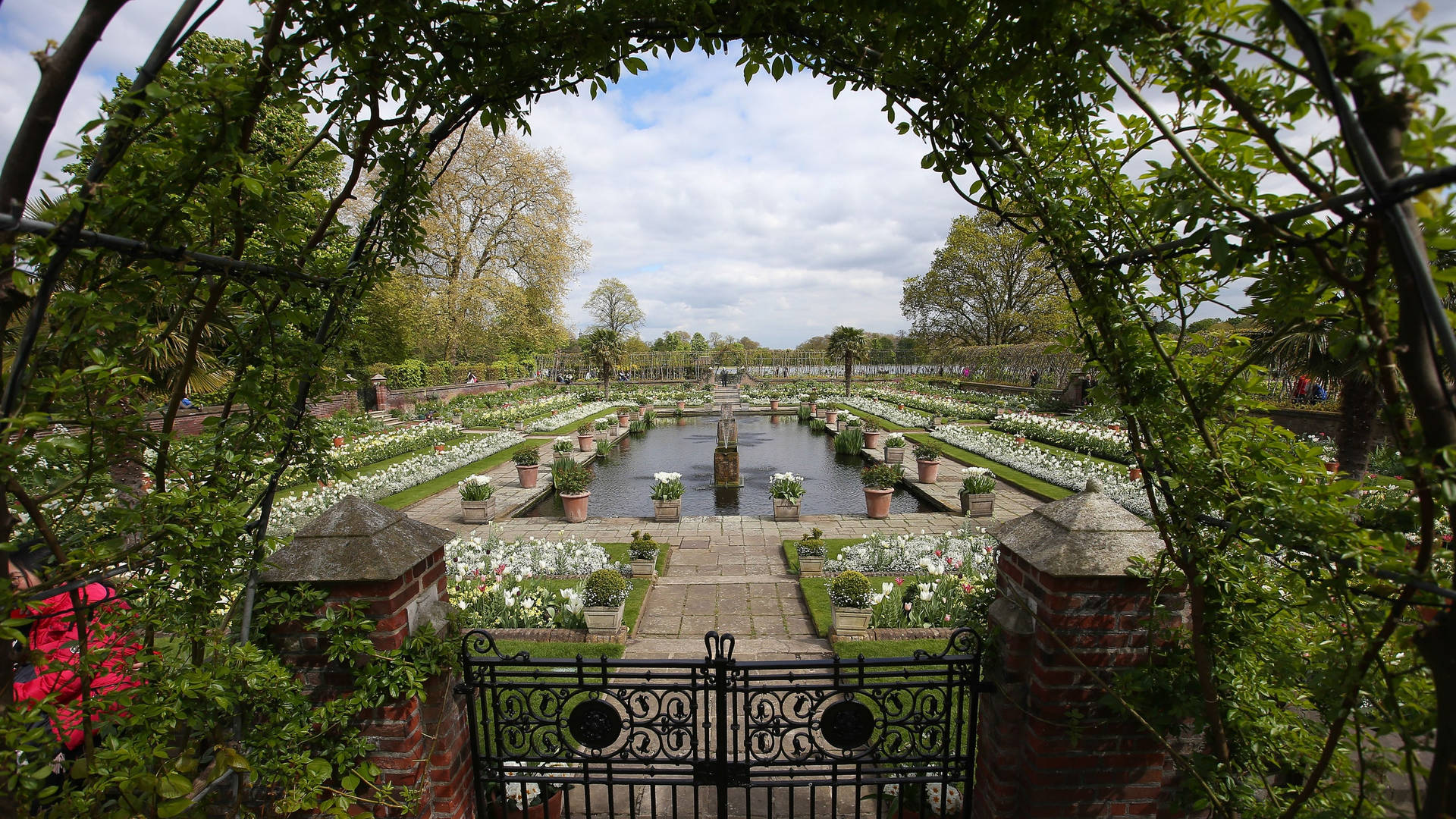 The Iconic Arch Entrance Leading Into Lush Green Gardens Of Kensington Palace. Background