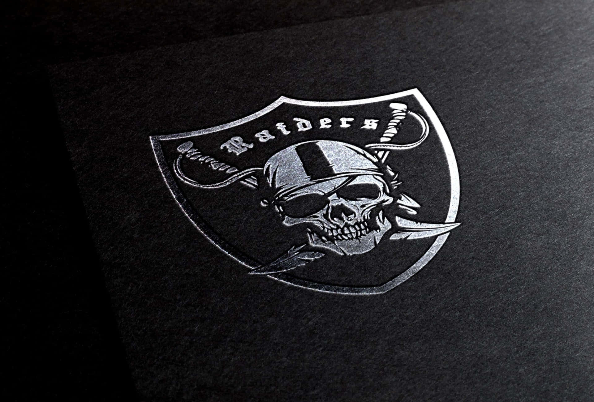 The Iconic Silver And Black Raiders Logo Background