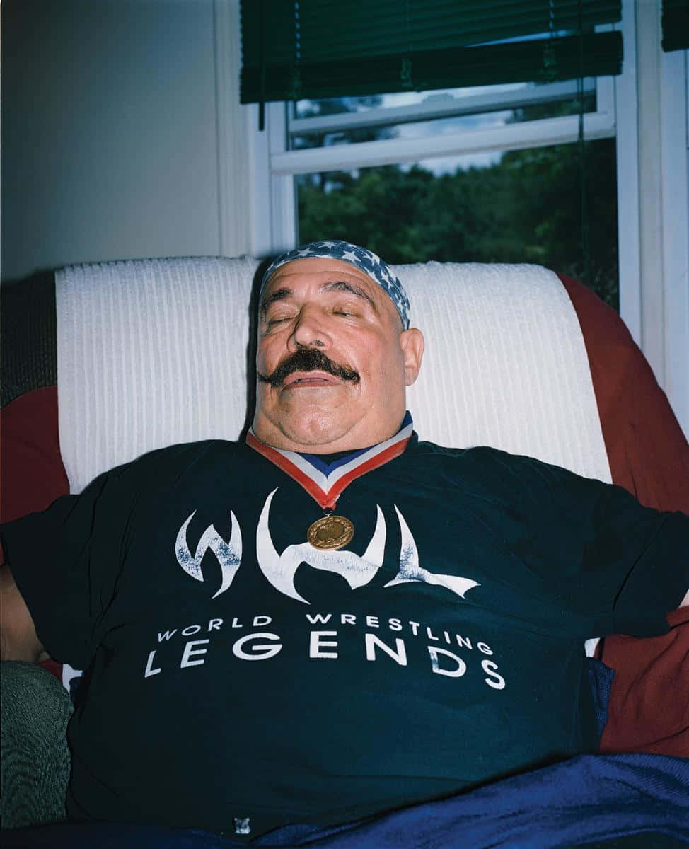 The Iron Sheik Relaxing On Sofa Background