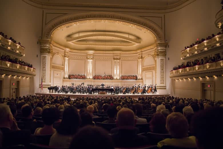 The Majestic Carnegie Hall Illuminated At Night Background