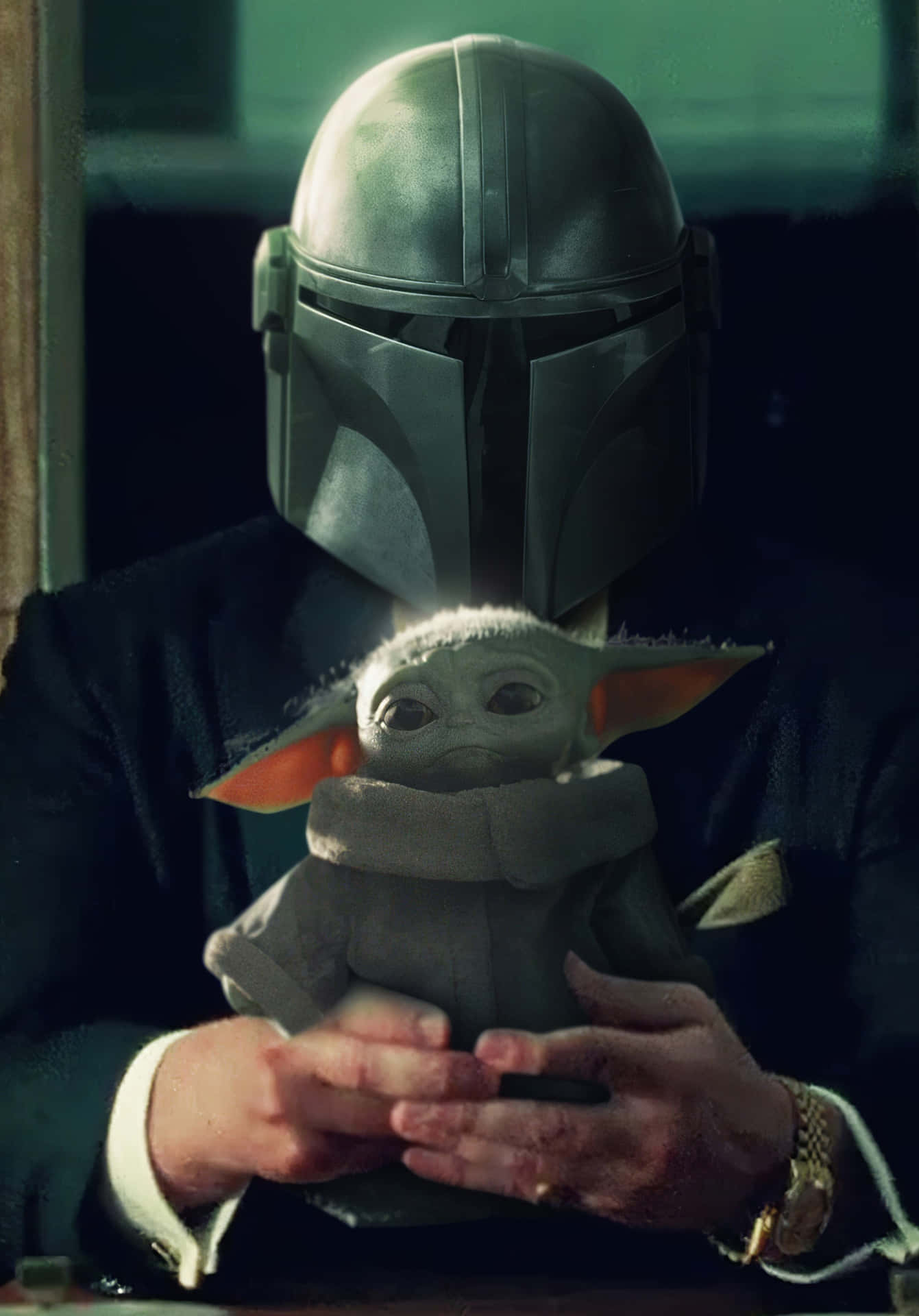 The Mandalorian Is Holding A Baby Doll Background