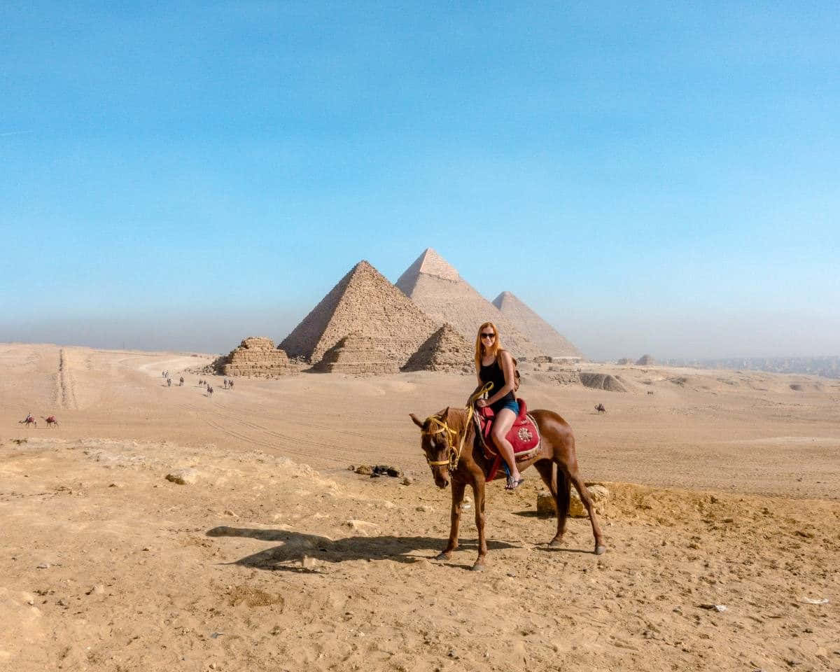 The Pyramids Of Giza Tourist On A Horseback Background