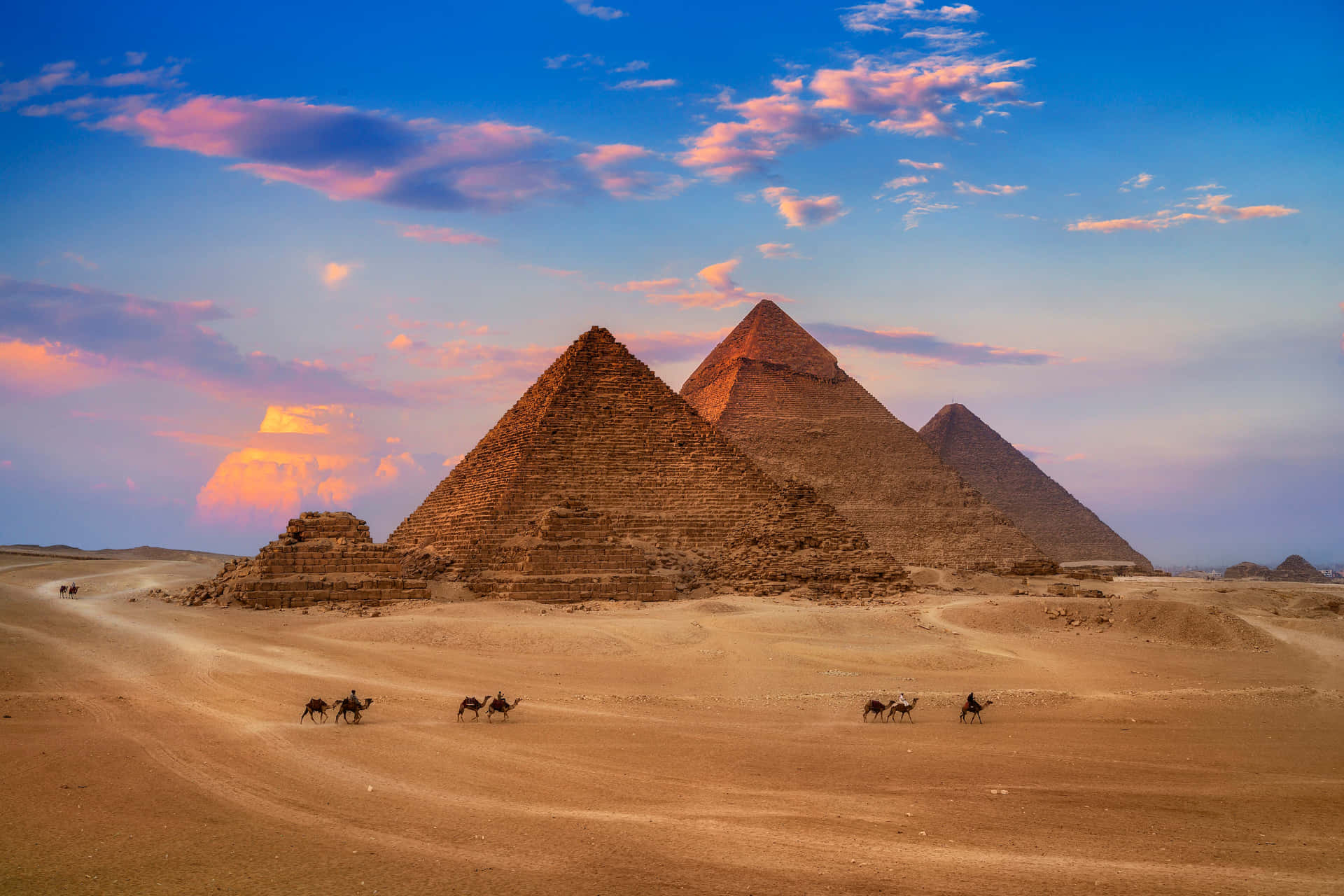 The Pyramids Of Giza With A Group Of Camels Background