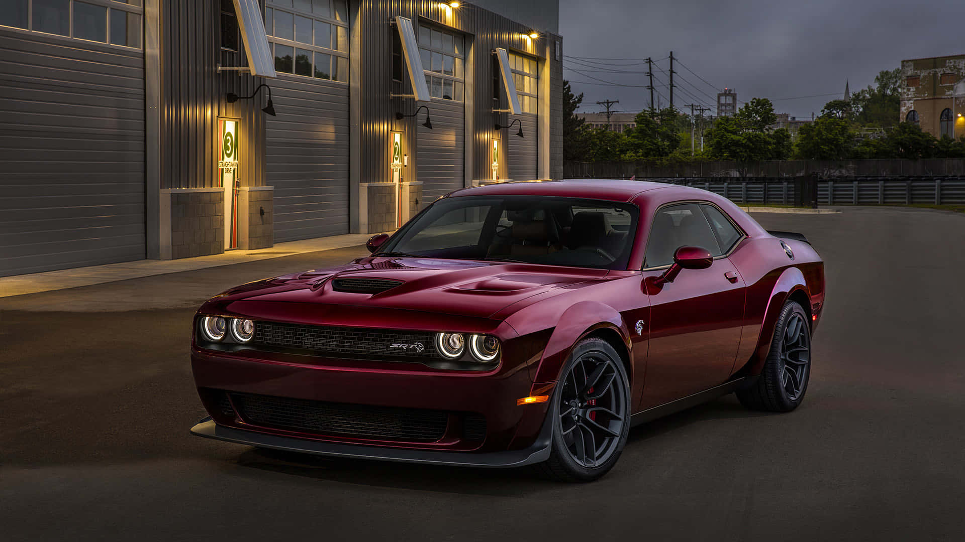 The Red 2019 Dodge Challenger Srt Is Parked In Front Of A Garage Background