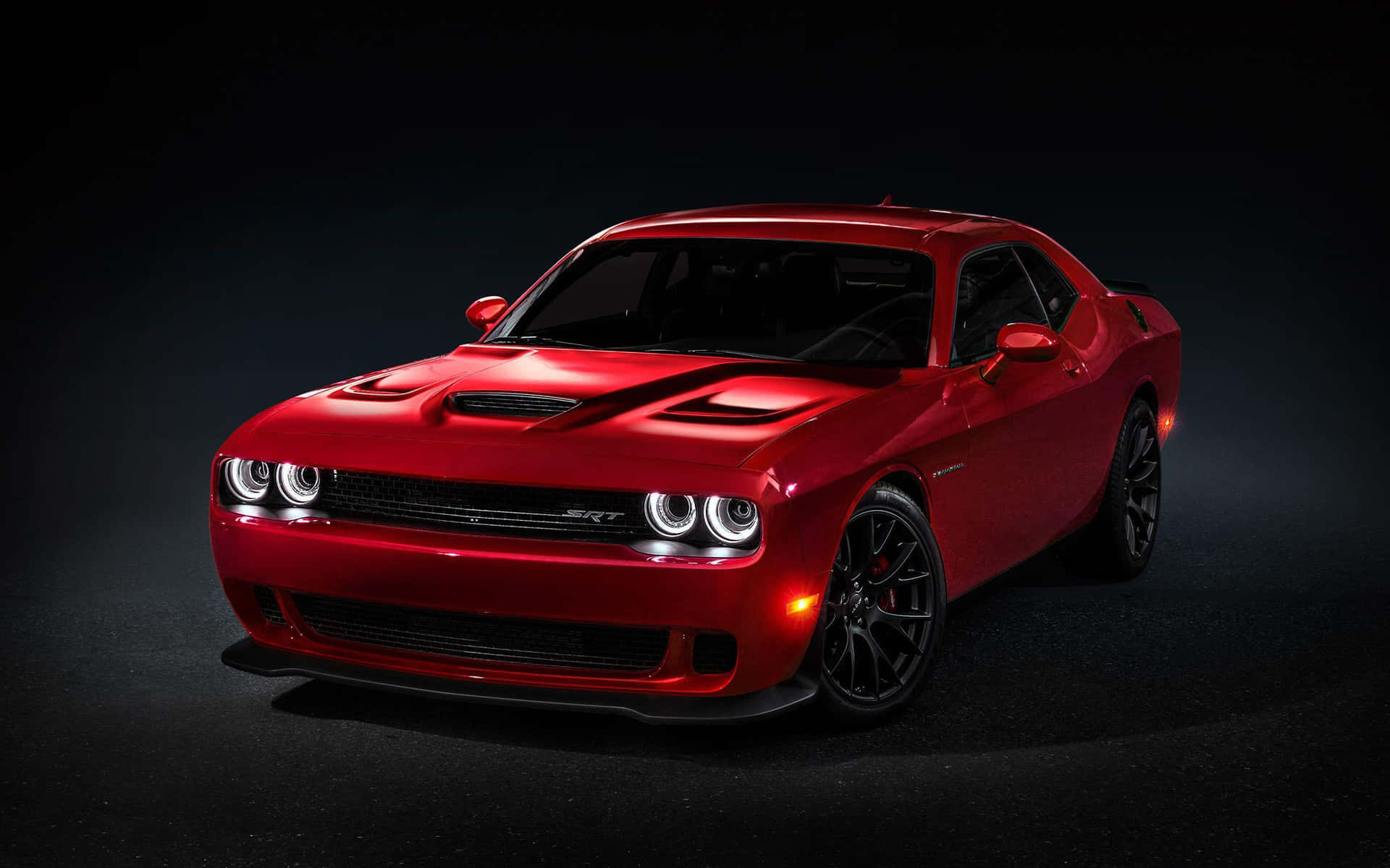 The Red Dodge Challenger Is Shown In A Dark Room Background