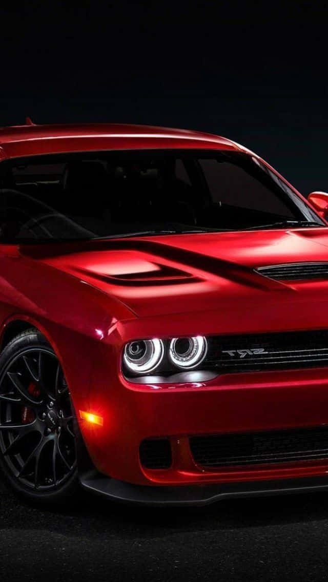 The Red Dodge Challenger Srt Is Shown In A Dark Room Background