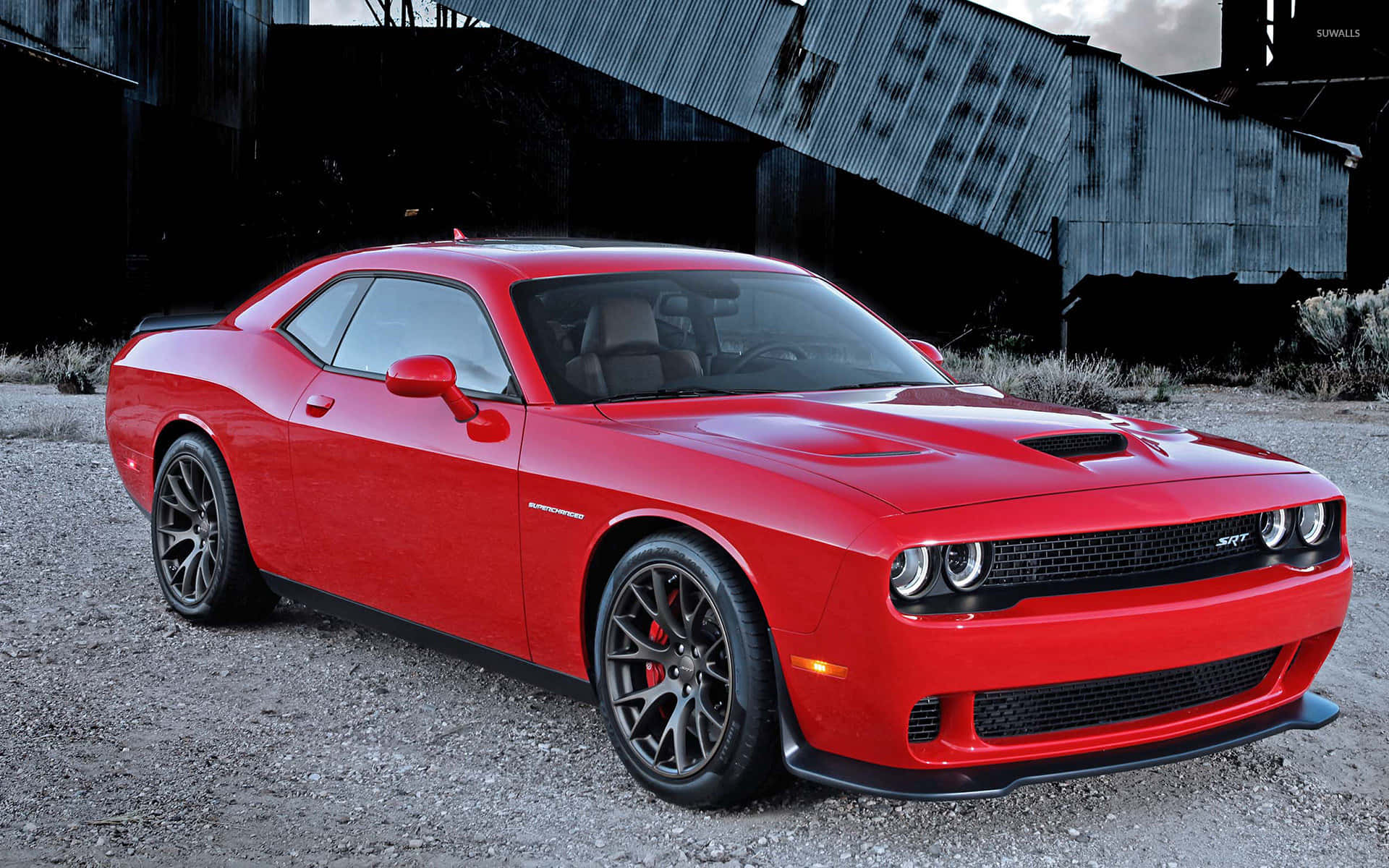 The Red Dodge Challenger Srt Parked In Front Of An Old Building