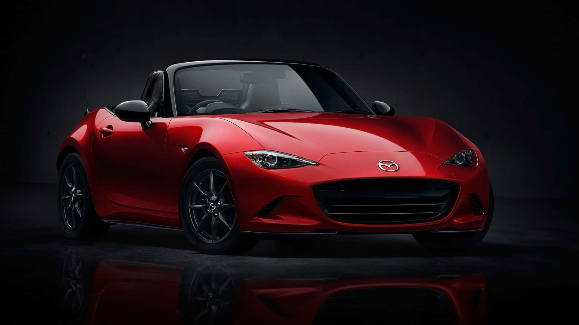 The Red Mazda Mx-5 Roadster Is Shown In A Dark Room Background