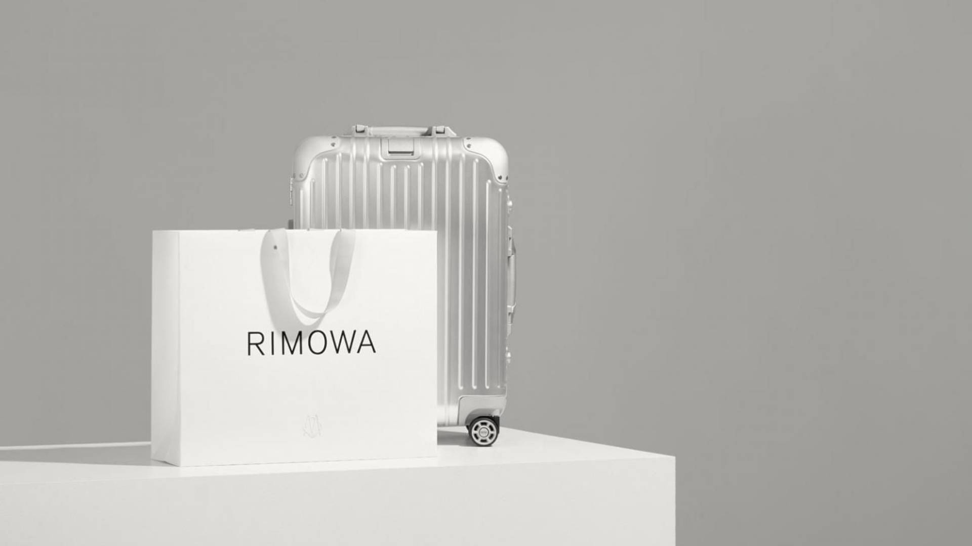 The Sophisticated Silver Rimowa Suitcase Background