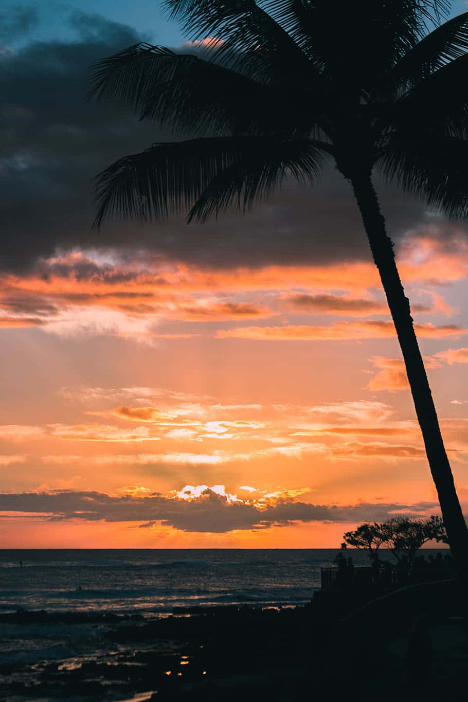 The Sun Setting Over A Stunning Beach In Hawaii Background