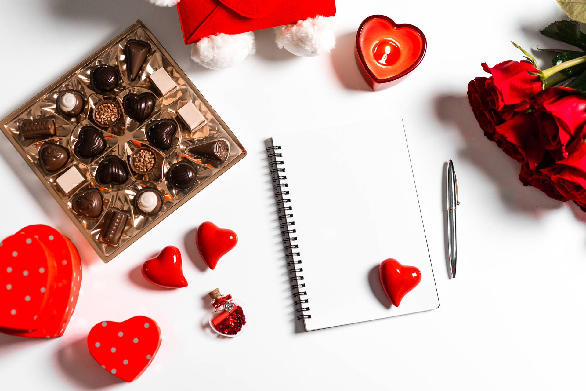 The Symbol Of Love: Romantic Flowers With Chocolates And A Notebook Background