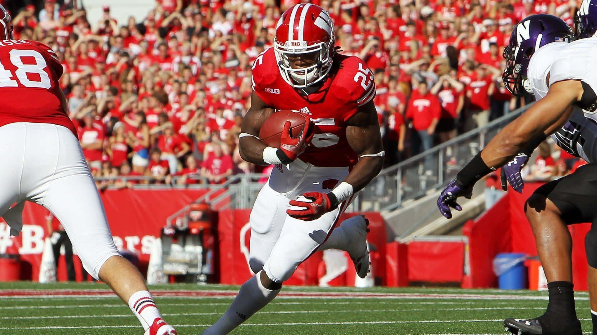 The Wisconsin Badgers Logo Displayed Proudly On A Stadium Field Background